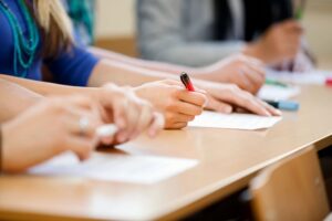 Students at desk with pen and paper