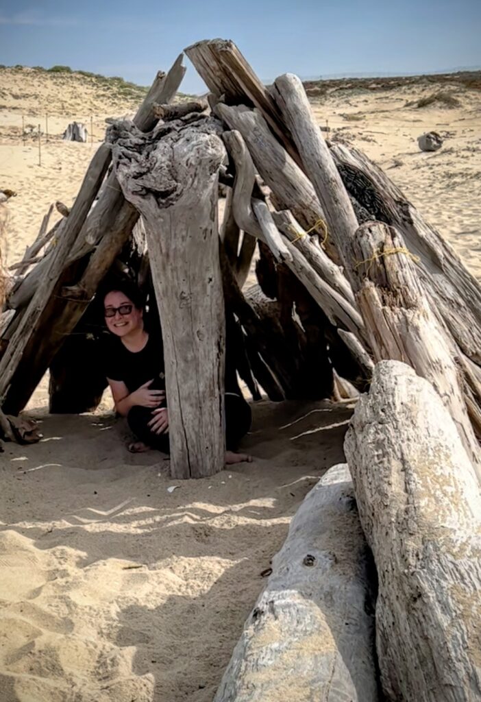 teaching outside in a drfitwood shelter on the beach